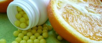 Аскорбиновая кислота в драже и половина апельсина